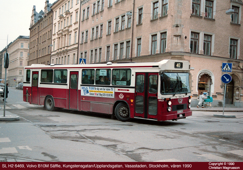 sl6469_19900000.jpg - Det här är ett speciellt exemplar av H2. Dels har den en generation av Säffle-karossen som annars inte förekom hos SL. Den har fortfarande stående lyktor fram men har fått det nya blinkersarrangemanget och det nya, större skyltskåpet (även om SL körde vidare med enbart linjenummer ett bra tag till). Dels ser man att bränslepåfyllningshålet sitter på en ovanlig plats, vilket tyder på att detta var ett av de exemplar i vilket man tidigare hade provat alternativa drivkällor. Troligtvis var detta den så kallade svänghjulsbussen.